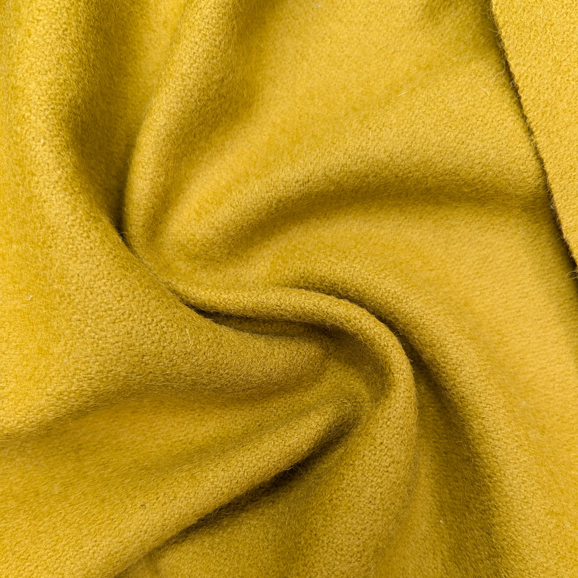 Arrowwood yellow virgin wool deadstock fabric, soft and warm, shown with gentle folds.
