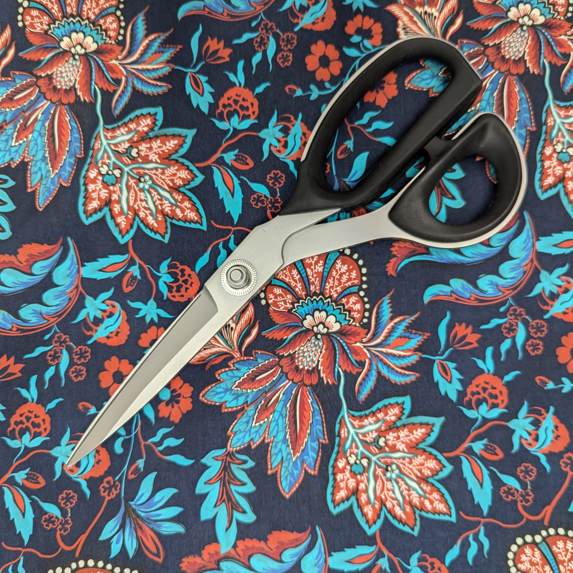 Designer deadstock parachute silk in Pantone Sky Captain with vibrant red and blue floral pattern.