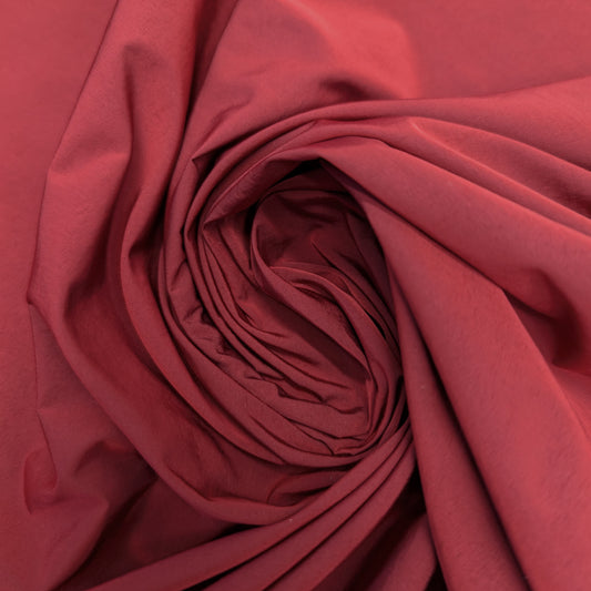 Deadstock Taffeta fabric in Pantone Rythmic Red, 120 cm wide, with a subtle sheen and elegant folds.