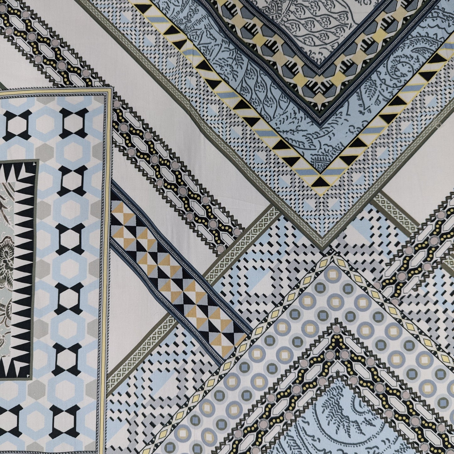 Mehrfarbiger Baumwollpoplin Deadstock mit geometrischen Mustern in Blau, Grau, Gelb und Schwarz.