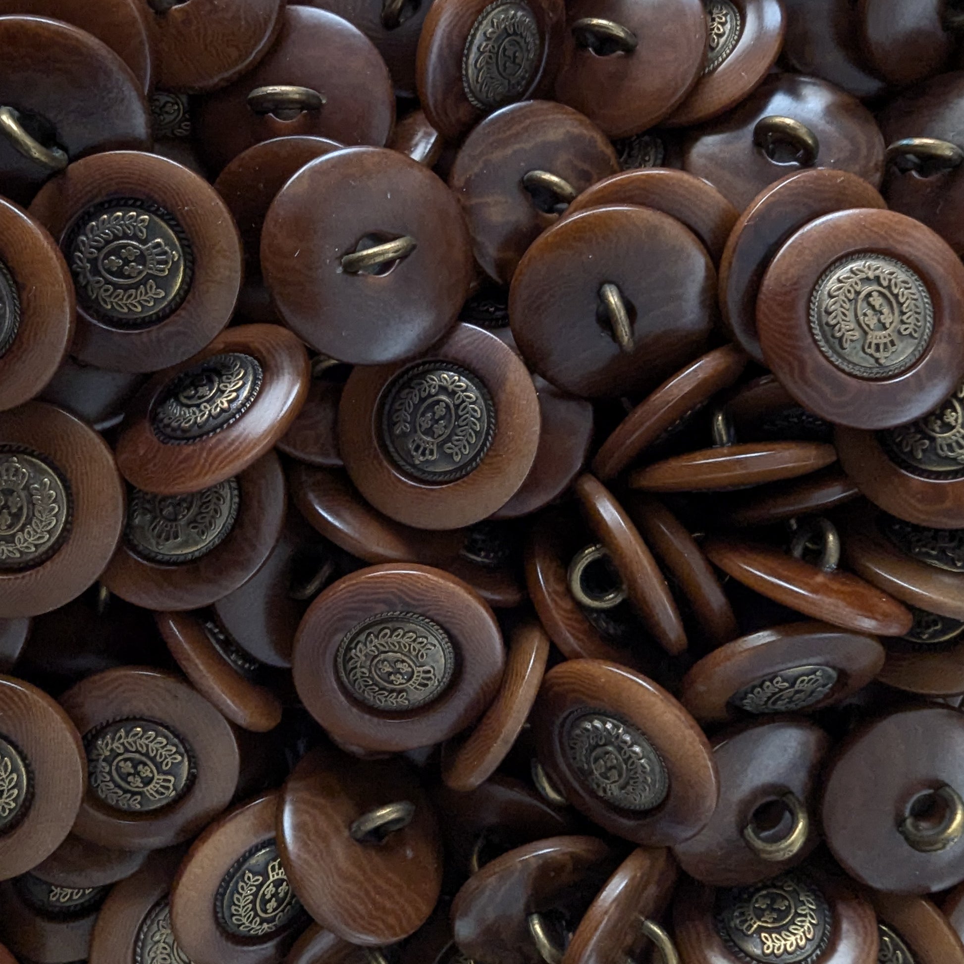 Dark brown Bongossi wood buttons with antique brass-colored metal crests, 2cm, for sewing.
