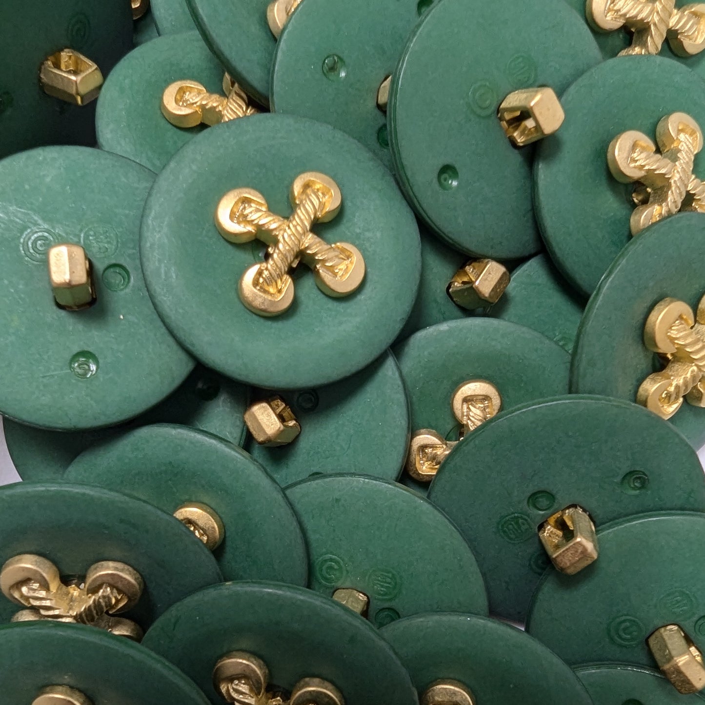 Six round, dark green buttons, each with a decorative gold metal element in a cross shape, about 3 cm.
