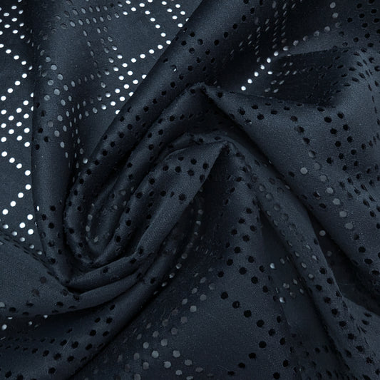 Black Beauty Woll-Viskose deadstock fabric with intricate laser-cut perforations, draped in soft folds.