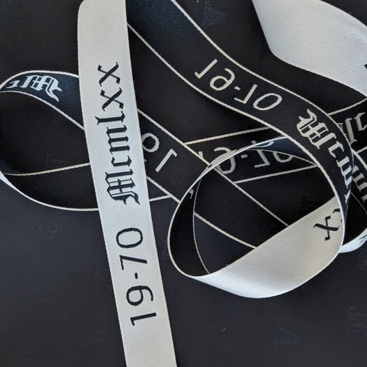 Black and white S*venty V*nezia webband trim with "19-70 McmLxx" text, 100 cm.