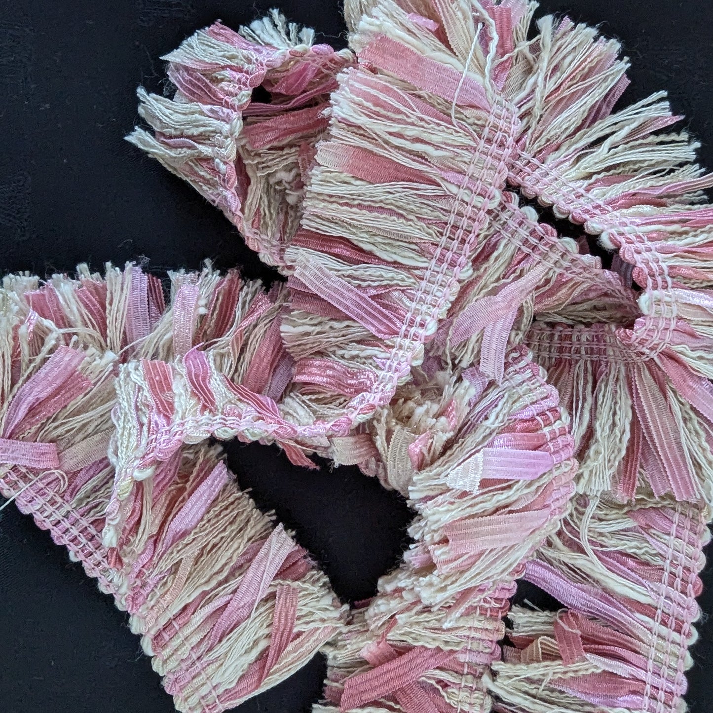 Pink and beige textured tweed trim, 100 cm, with fringed edges, on a black background.