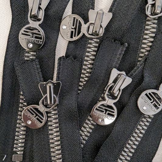 Black YKK zipper with metallic black teeth, round Sportalm logo pull with a rhinestone, 11 cm.