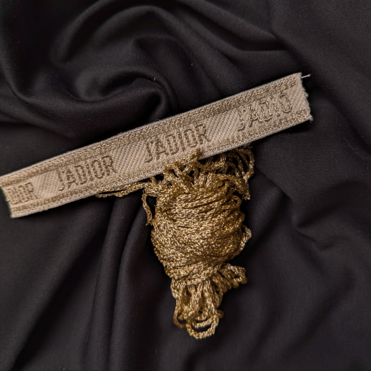Gold J'ADIOR silk-lurex DIY bracelet band, 14x2 cm, with matching coiled thread on dark fabric.