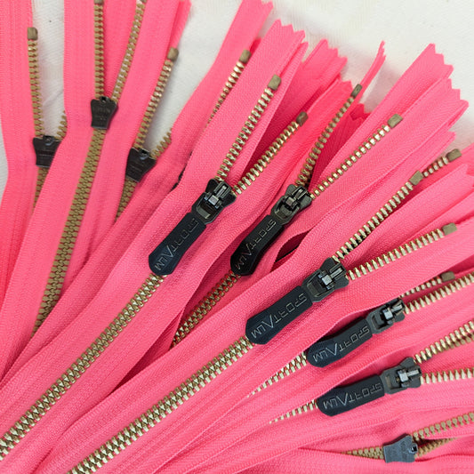 Neon pink zippers with golden metal teeth and black designer pullers, 30 cm long.