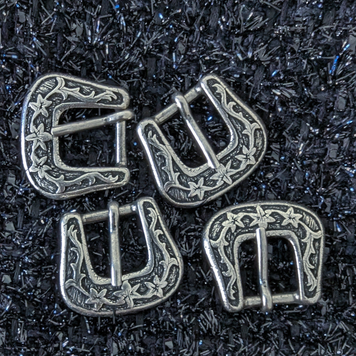Four antique silver metal deadstock buckles, 3.5x4cm, with ornate floral engraving.
