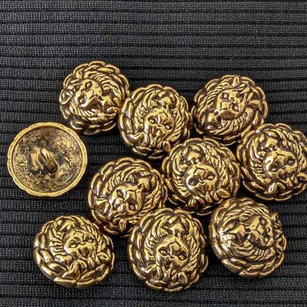 Ten round, gold brass buttons with an embossed lion head design, one showing the back.