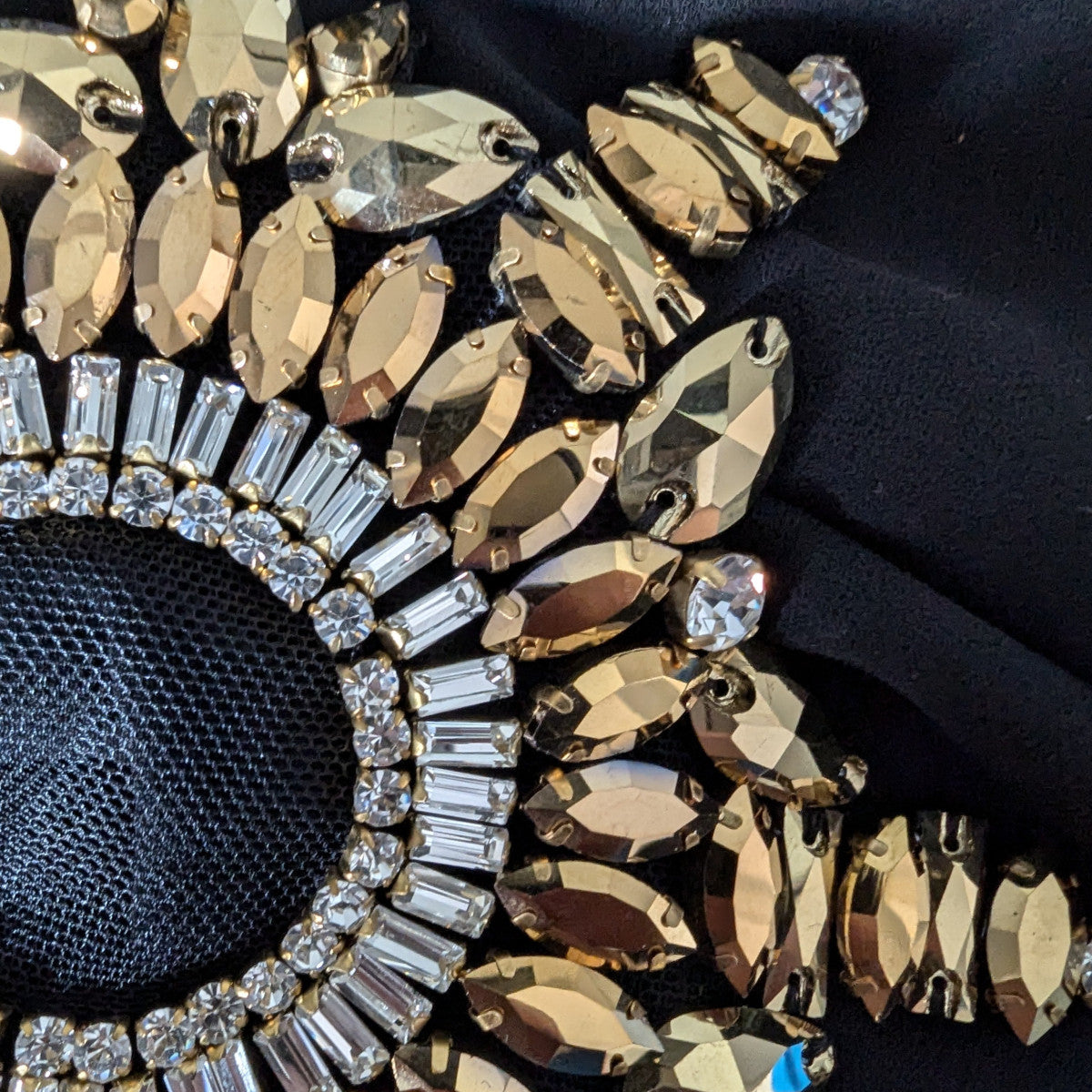 Close-up of a D&G heavy patch with gold Swarovski crystals, white rhinestones, and pearls on black mesh.
