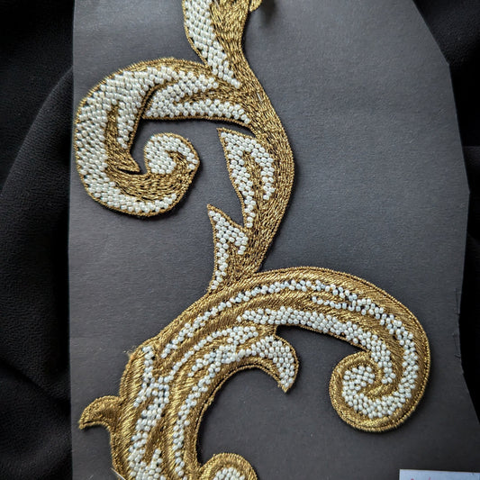 D&G gold metallic embroidered patch with white pearls, 9x14 cm, on a dark background.