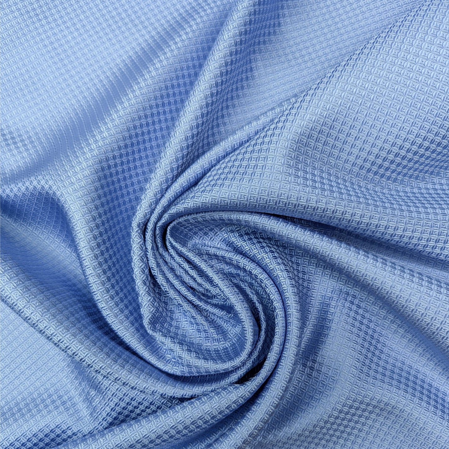 Glossy light blue silk satin-tone deadstock fabric, 65cm wide, with a subtle textured pattern.