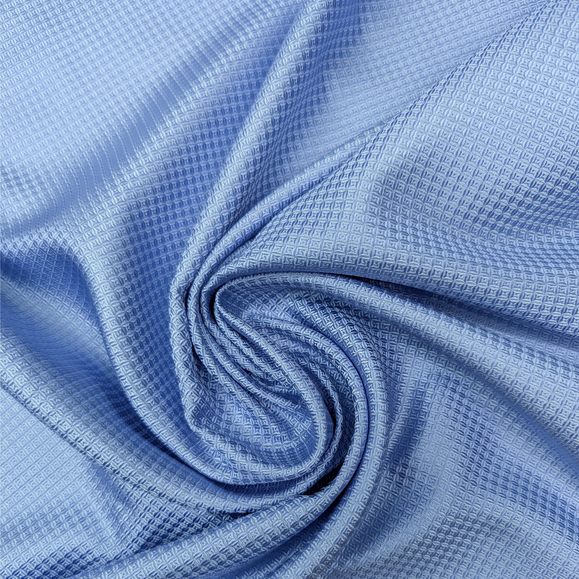 Glossy light blue silk satin-tone deadstock fabric, 65cm wide, with a subtle textured pattern.