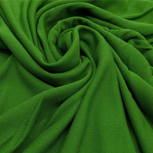 Deadstock D*or viscose crepe fabric in a vibrant matte green, draped with soft folds.