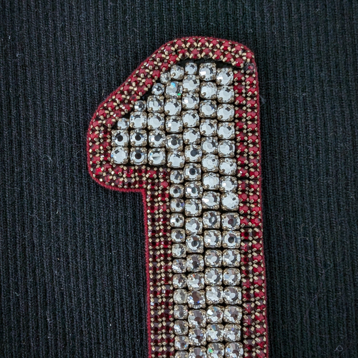 D&G "1" patch with sparkling clear pearls and red beaded trim on black fabric.