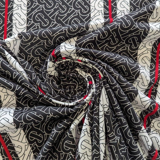 Black and white B*rberry monogram jersey deadstock fabric with subtle red stripes, swirled.