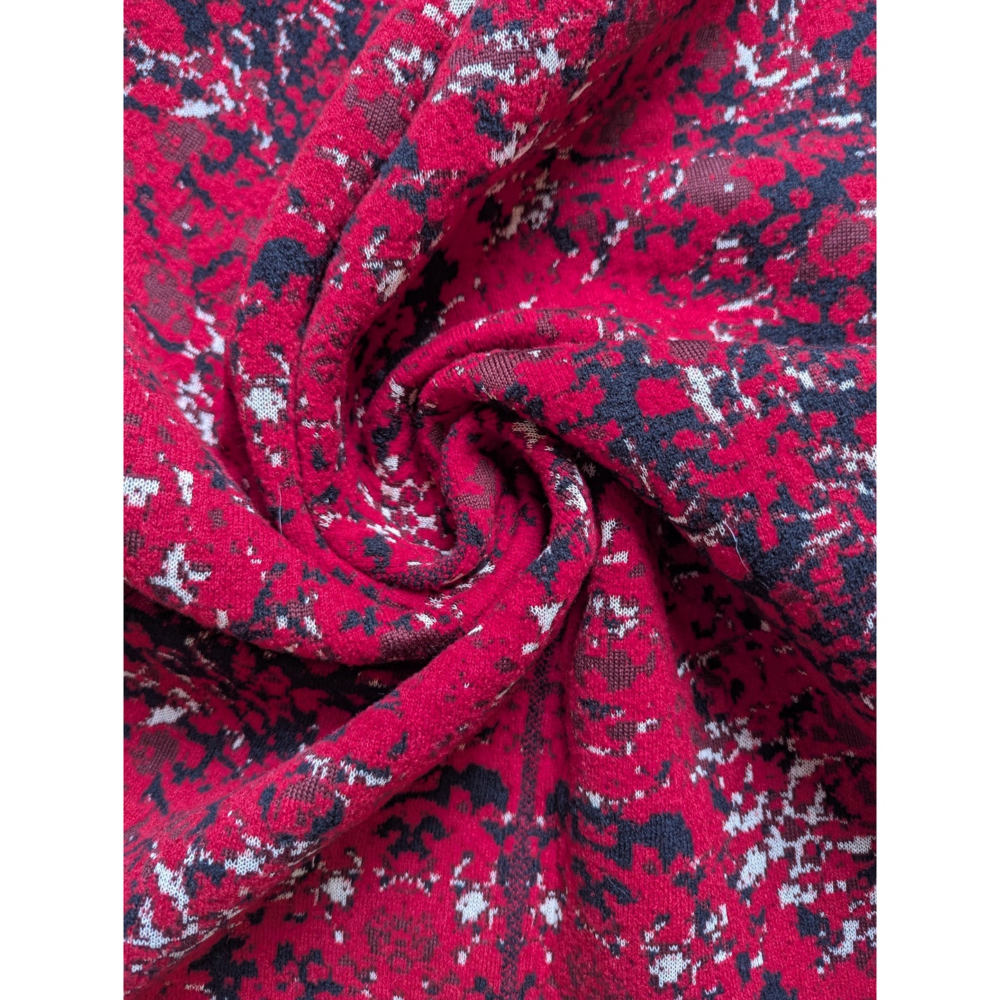 Red Missoni deadstock wool knit fabric with black and white abstract pattern, swirled.