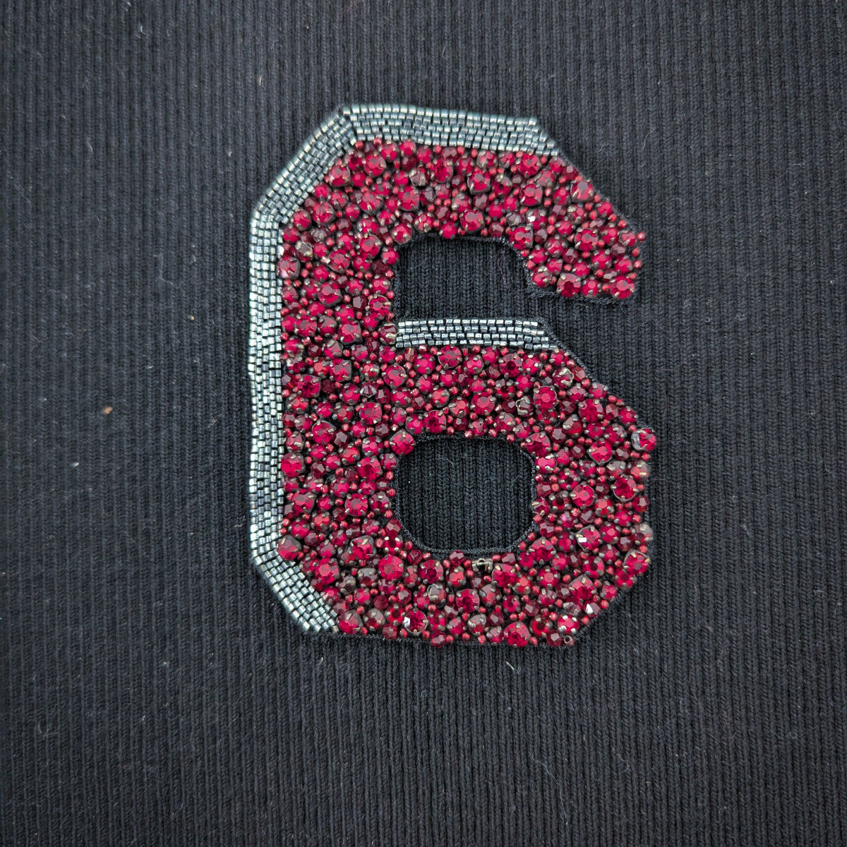 Embroidered D&G number 6 patch, 10cm, with red beads and silver pearl outline on black fabric.