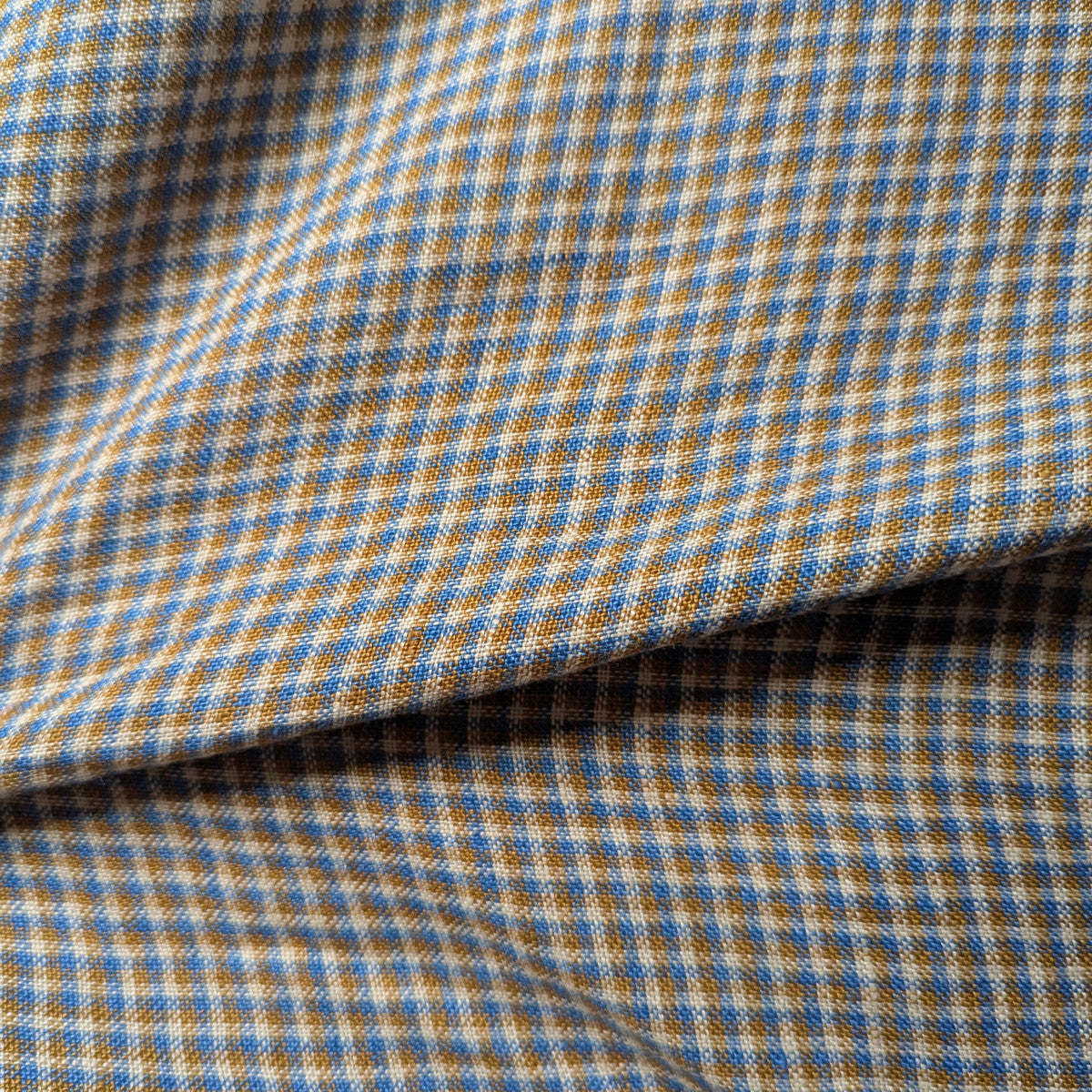 Deadstock linen-cotton blend fabric with blue, tan, and cream checkered pattern, natural texture.