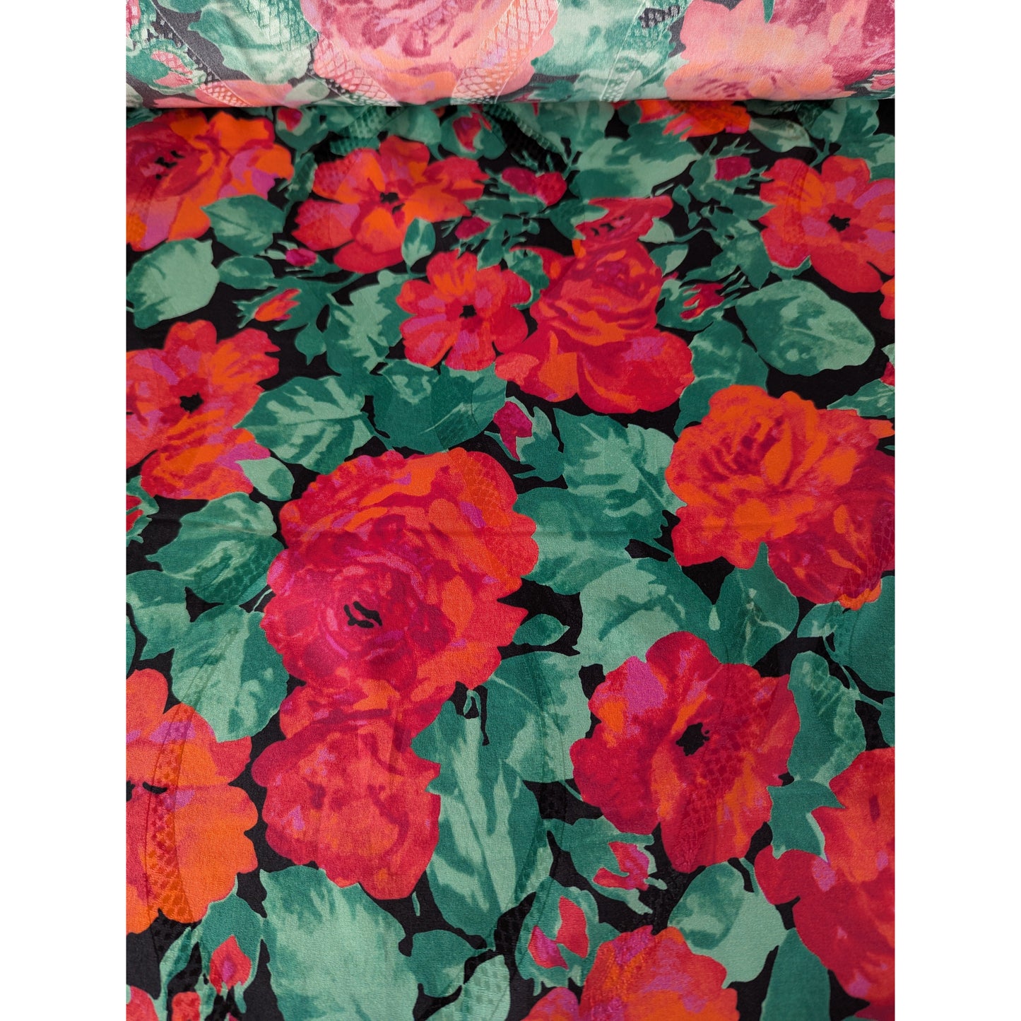 Luxurious deadstock Gucci jacquard silk fabric with vibrant red roses and green leaves on a dark background.