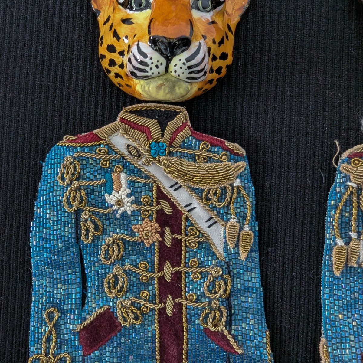 Embroidered D&G leopard head and blue uniform patch with gold details on black fabric.