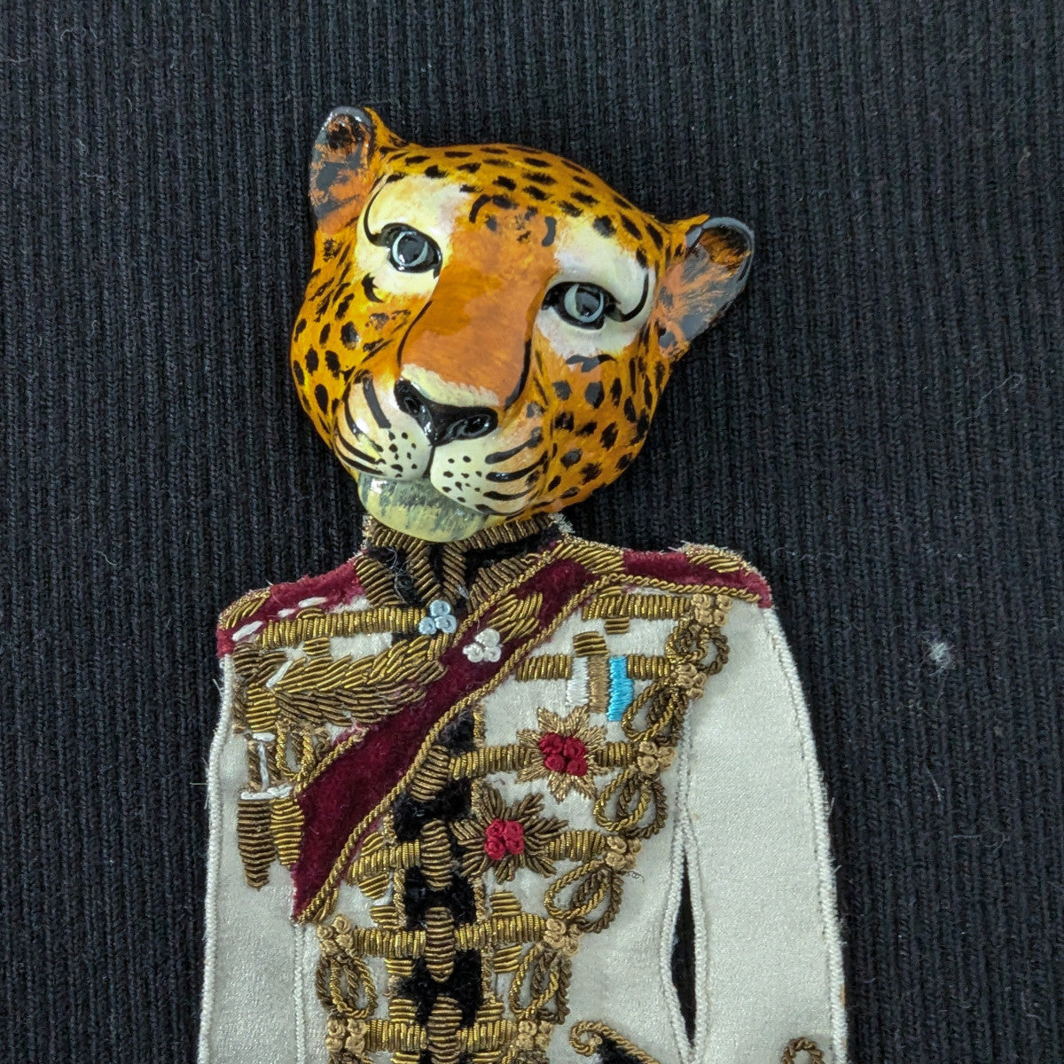 D&G leopard head patch in uniform, 15x8cm, with gold embroidery and red accents.