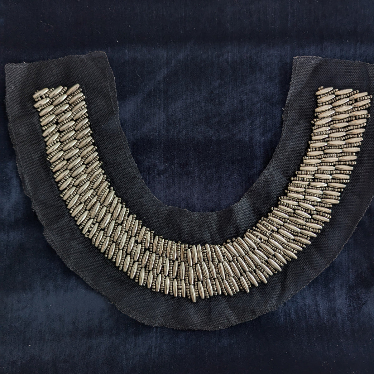 D&G black fabric patch with rows of silver metallic beads and pearls, shaped like a necklace.
