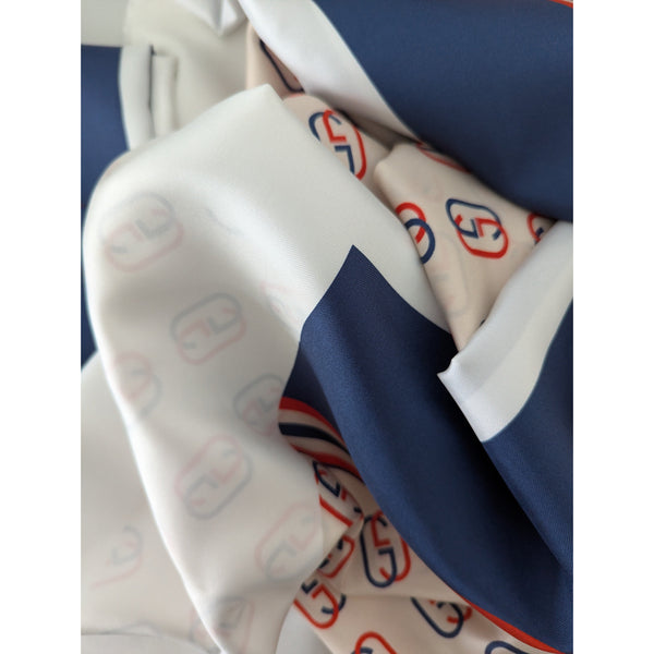 Cream and navy blue silk twill fabric with red designer logo print.