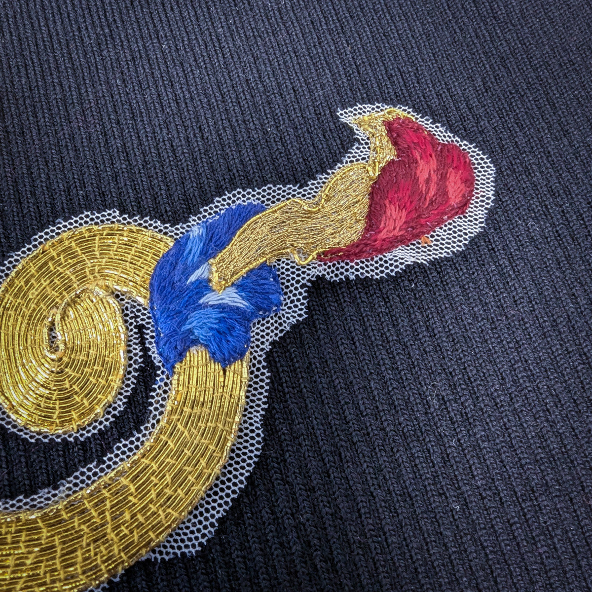 D&G gold, red, blue embroidered patch on fine tulle, 30x15 cm, on dark fabric.