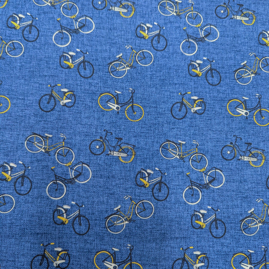 Blue cotton poplin deadstock fabric with a pattern of yellow, white, and black bicycles.
