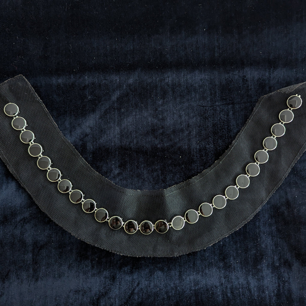 D&G black pearl patch with silver settings, curved on dark velvet.