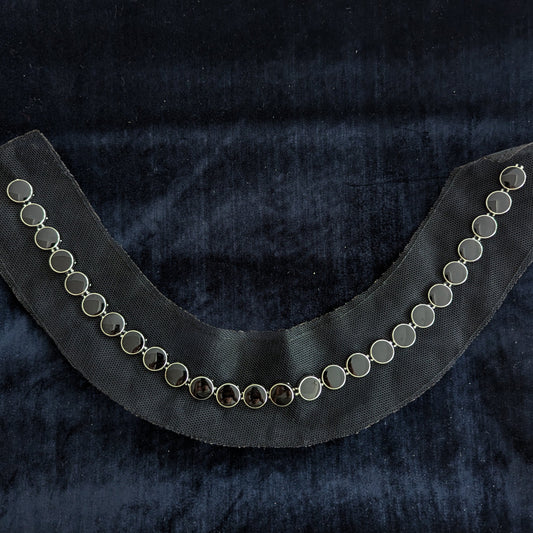 D&G black pearl patch with silver settings, curved on dark velvet.