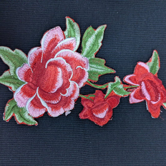 XXL G*cci embroidered red and pink rose patch with green leaves on black fabric.
