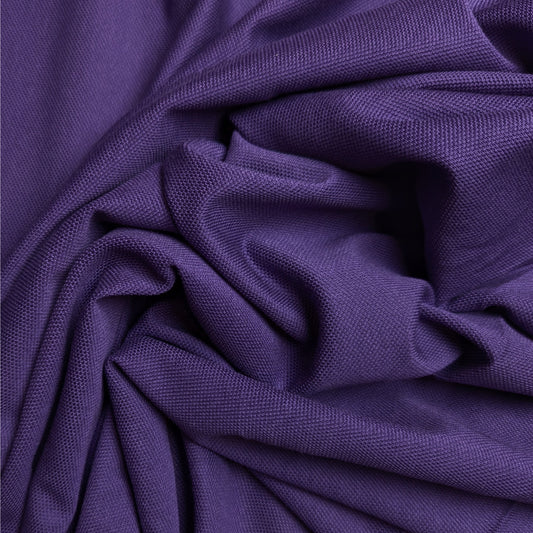 Textured purple cotton piqué fabric, draped and folded, showing its distinct weave.