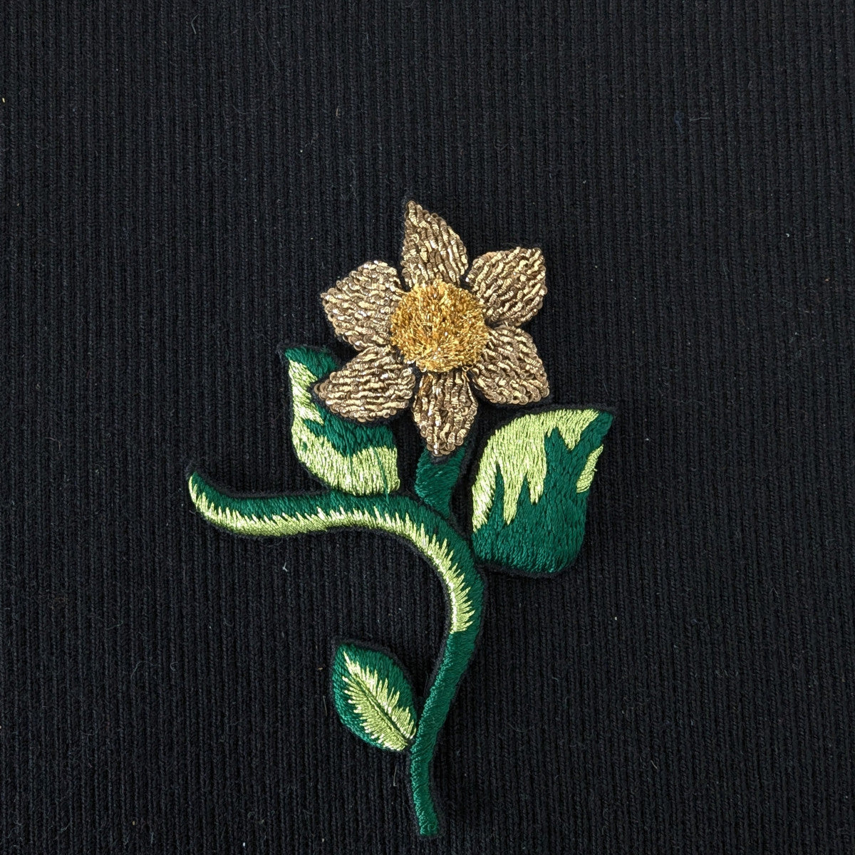 D&G gold and green embroidered flower patch, 13cm, with detailed petals and leaves on black fabric.