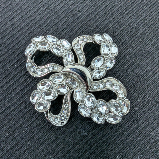 D&G silver-plated metal ornament with sparkling Swarovski stones, 4x4cm filigree bow design.