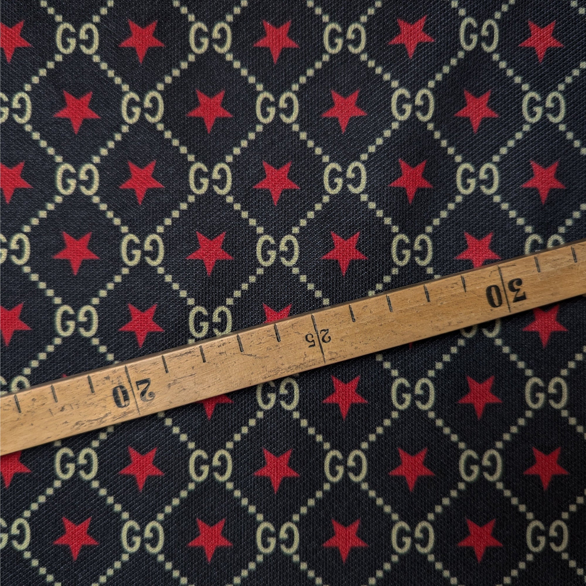 Deadstock G###i dark blue Punto Milano jersey with beige GG logo diamond grid and red stars, ruler for scale.