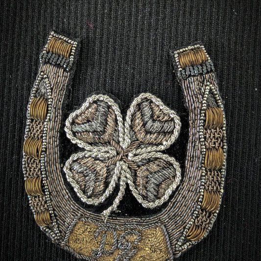 D&G metal embroidery patch: horseshoe with a four-leaf clover and logo, 8x9cm, on black fabric.