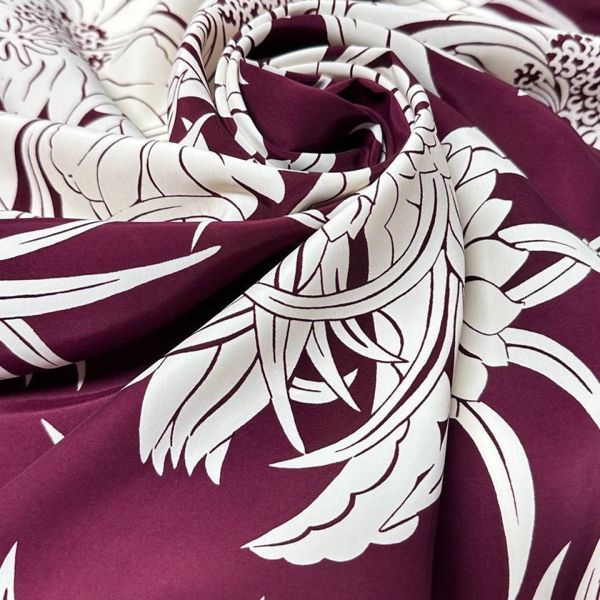 Deadstock burgundy viscose fabric with flowing white floral and leaf pattern, 50x140cm.