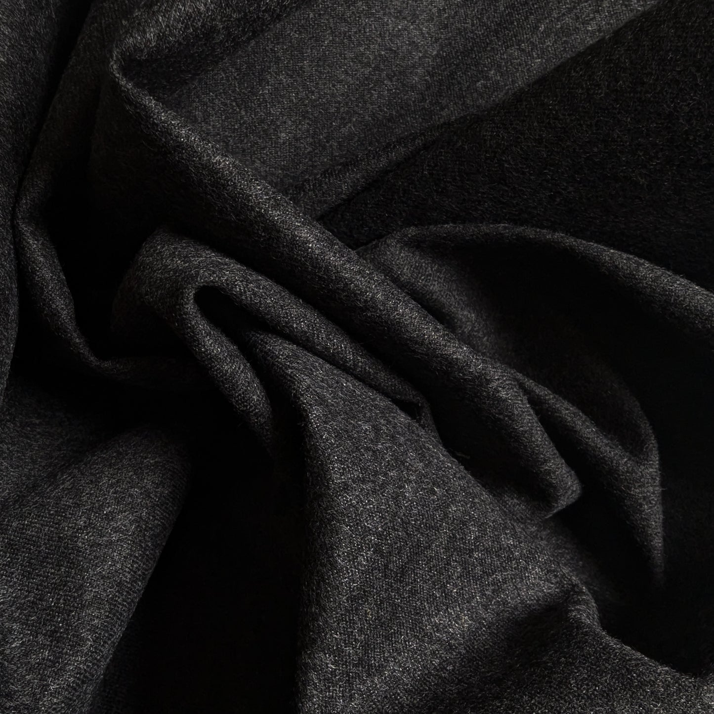 Dark gray cashmere Storm System fabric, draped with soft folds, ideal for coats and jackets.