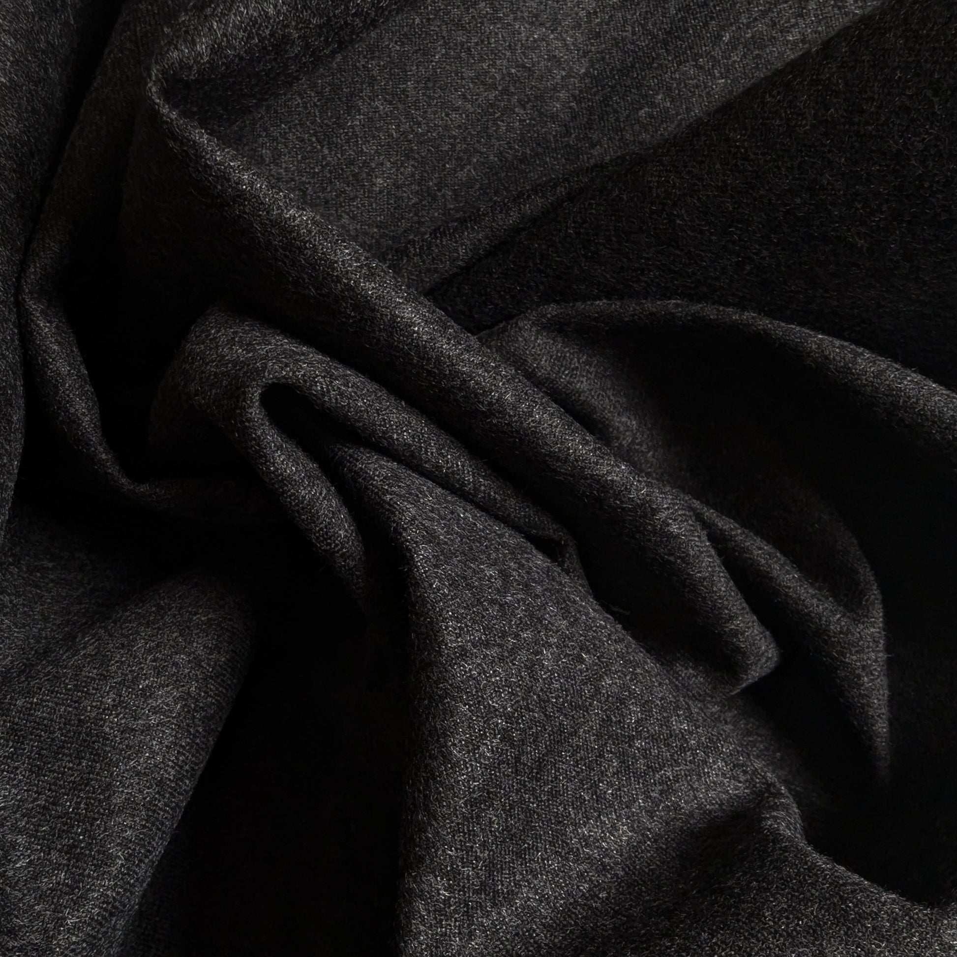 Dark gray cashmere Storm System fabric, draped with soft folds, ideal for coats and jackets.