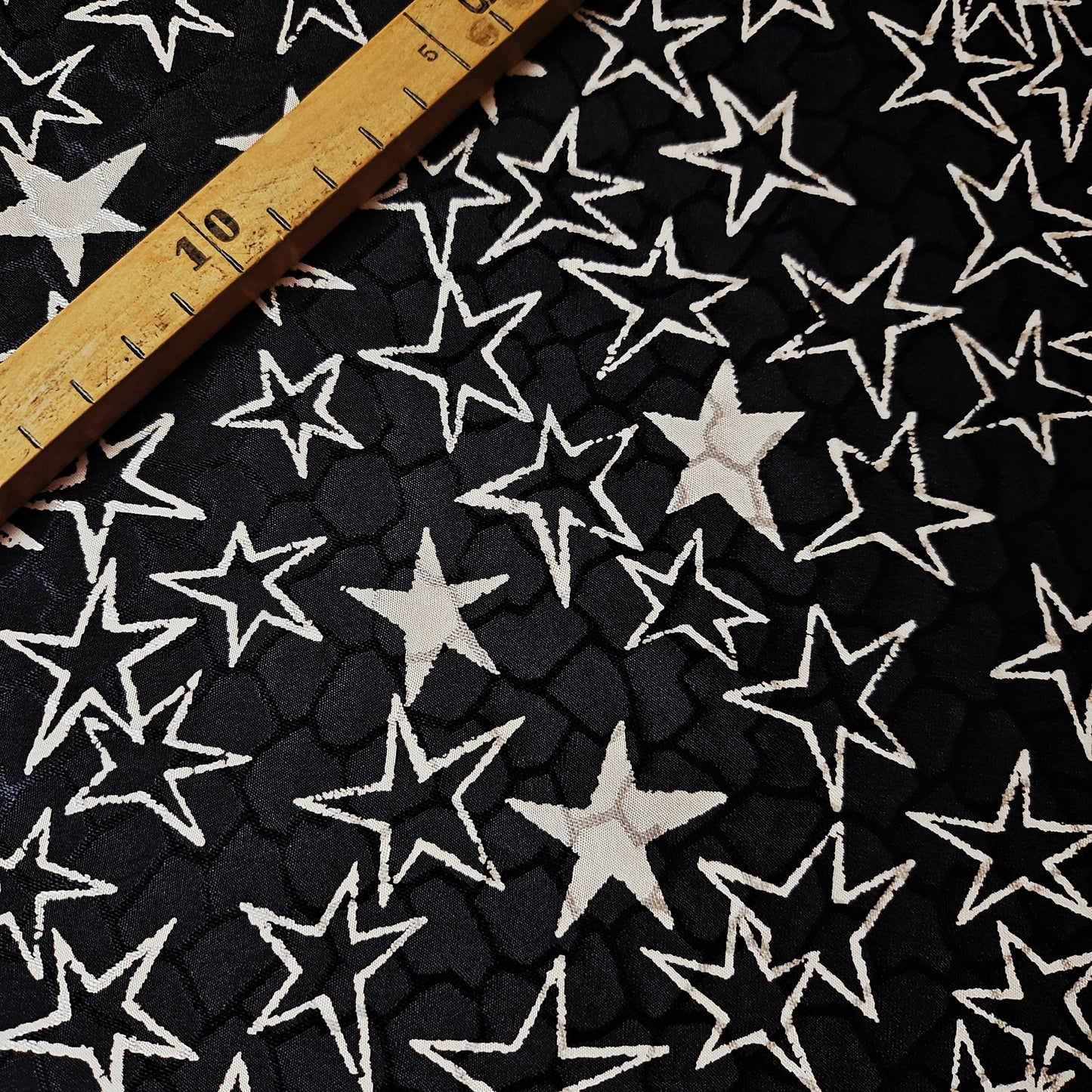 Black and off-white YSL deadstock silk jacquard fabric with star pattern and ruler.