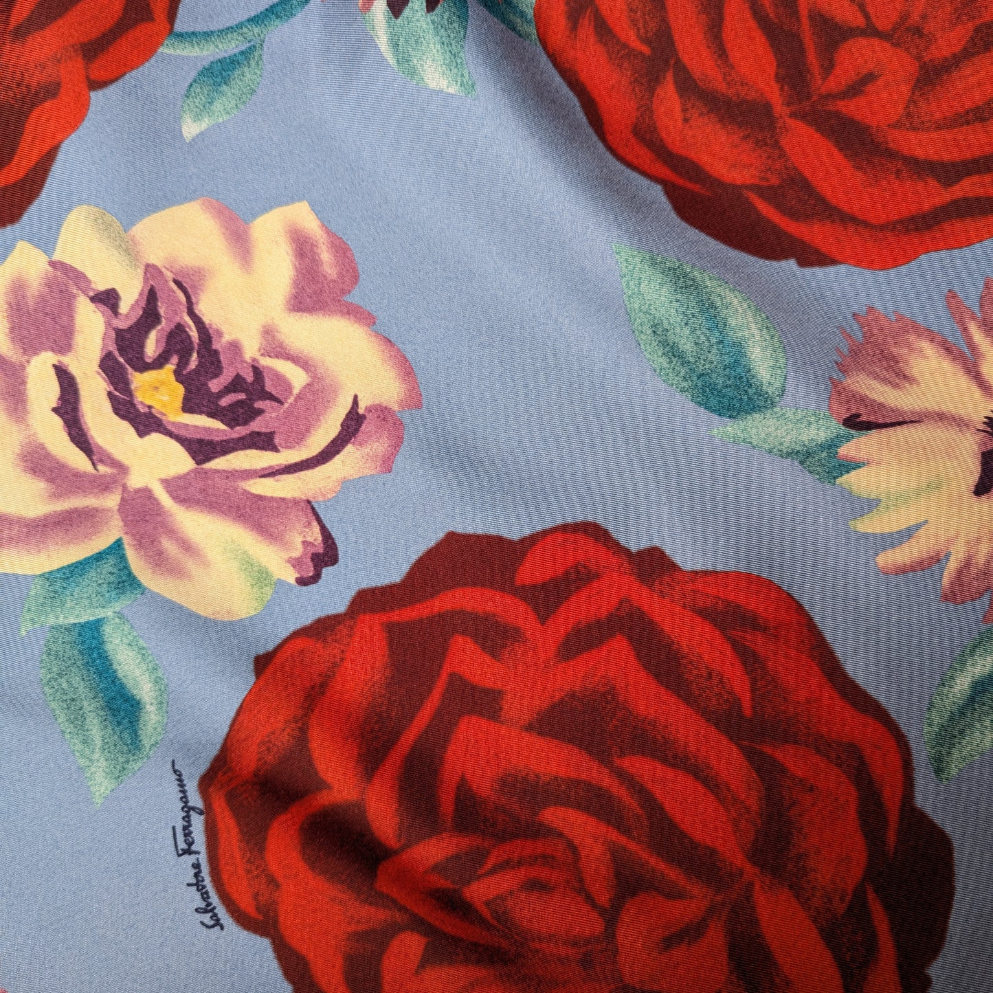 Light blue silk twill deadstock fabric with large red and cream floral print.