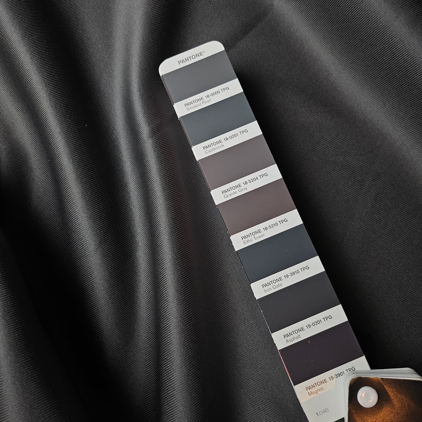 F*ndi deadstock heavy acetate jersey fabric in Pantone Smoked Pearl, showing smooth drape, with color swatch.