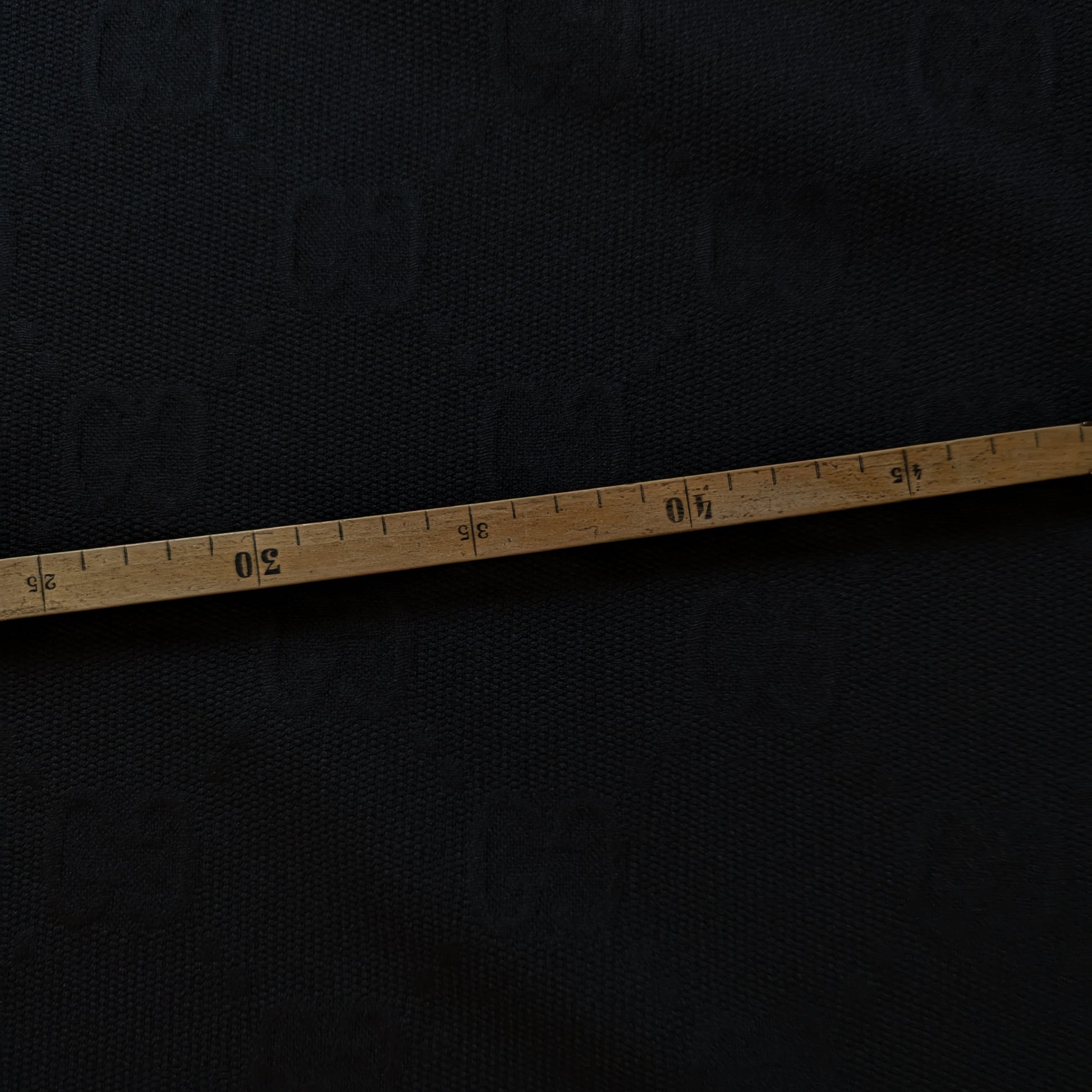 Black G*cci polyester jacquard fabric, textured with a woven tone-on-tone logo, measured by a wooden tape.