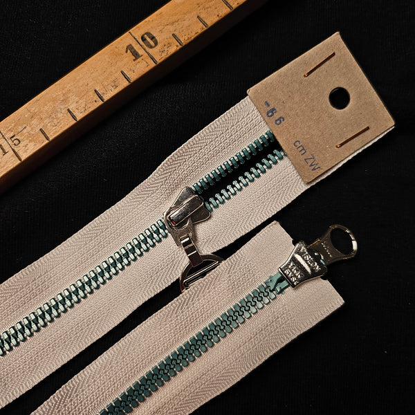 66 cm Sportalm two-way zipper with cream tape, teal plastic teeth, and silver metal pulls.
