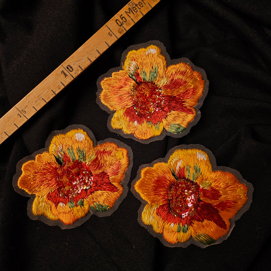Three hand-embroidered D&G flower patches, 7x9cm, with orange, yellow, and red petals on black fabric.