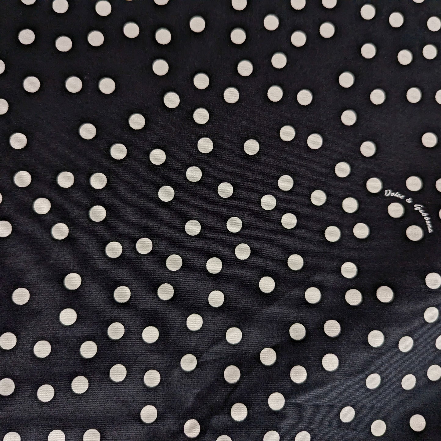 Black D&G cotton deadstock fabric with scattered white polka dots, ideal for linings.