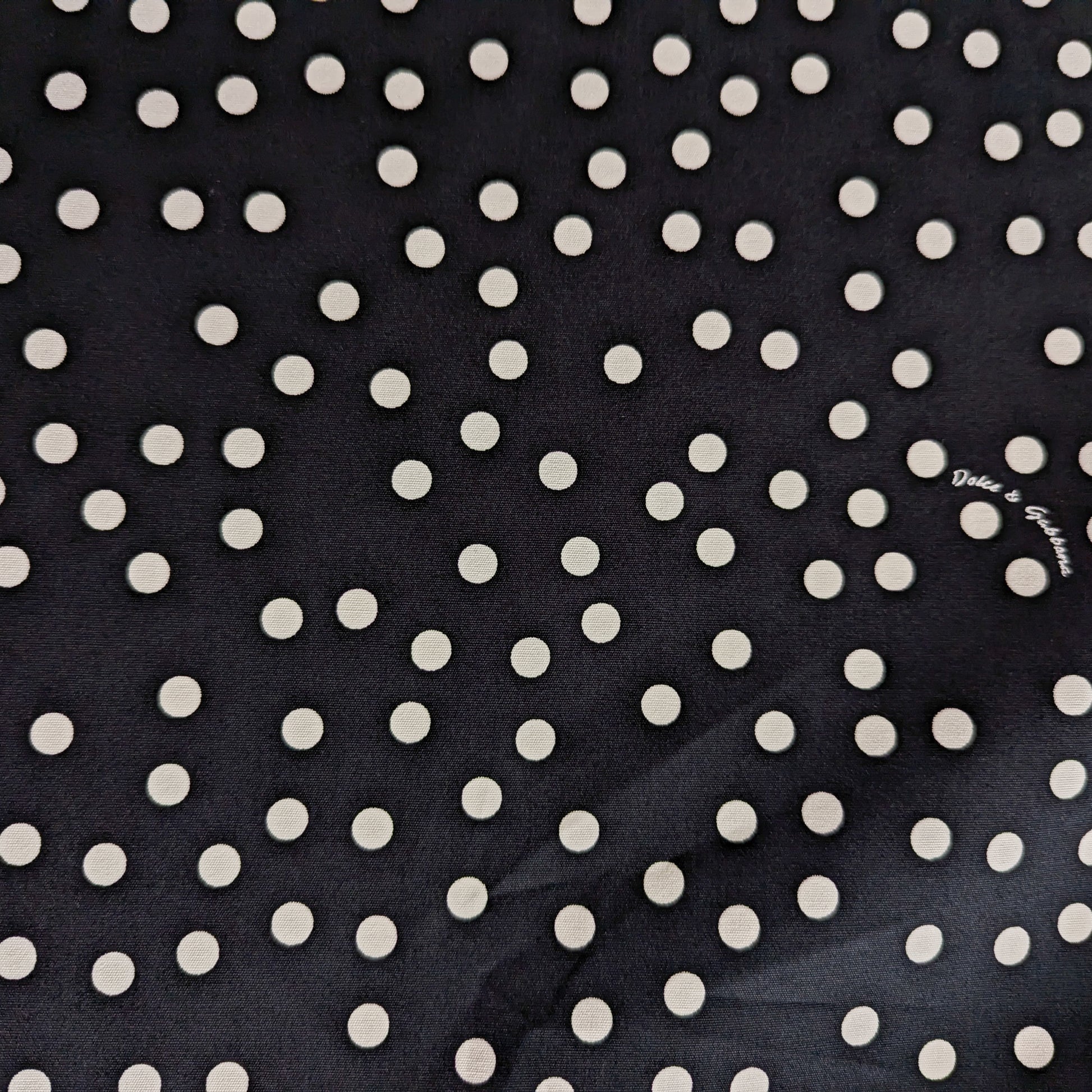 Black D&G cotton deadstock fabric with scattered white polka dots, ideal for linings.